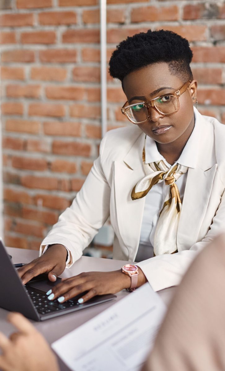 African American CEO using computer and communicating with a candidate during job interview in the office.